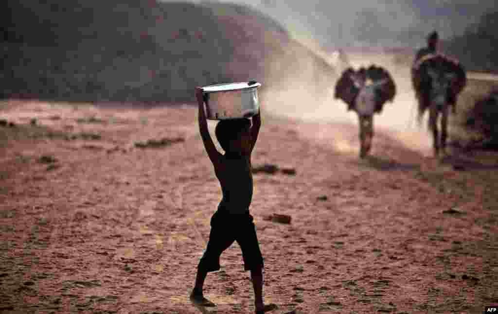 June 2: A Pakistani boy walks toward a water point to collect water for his family, on the outskirts of Islamabad, Pakistan. (AP Photo)