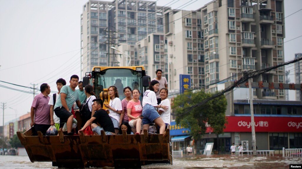 河南郑州暴雨后居民乘坐斗车疏散。（2021年7月23日）(photo:VOA)