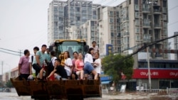 河南鄭州暴雨後居民乘坐斗車疏散。 （2021年7月23日）