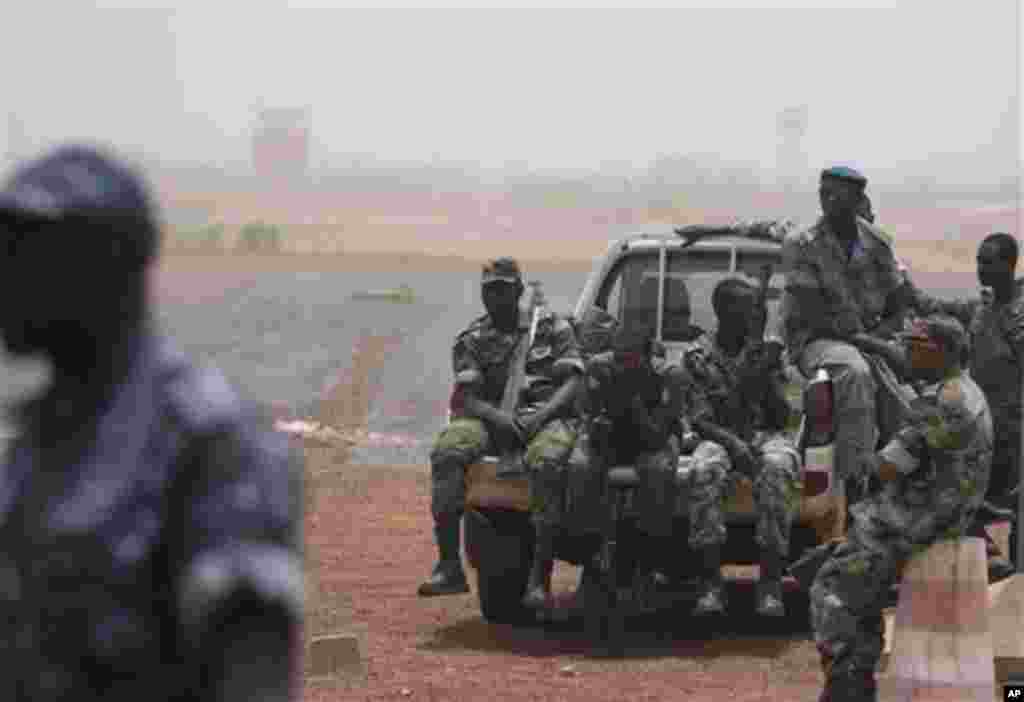 Soldiers sit guard on the tarmac of the international airport, where coup leader Capt. Amadou Haya Sanogo had been due to meet a delegation of West African presidents, in Bamako, Mali Thursday, March 29, 2012.