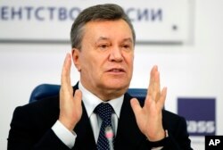 FILE - Former Ukraine President Viktor Yanukovych gestures as he speaks at a news conference in Moscow, Russia, March 2, 2018.