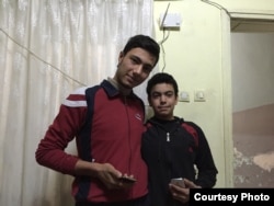 Syrian refugees Ahmet, 19, and his 15 year-old brother Muhammet pose with their smartphones earlier this year in the apartment they share with their family in Gaziantep, Turkey.