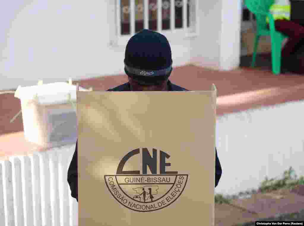 Um agente da polícia descarrega o voto antecipado numa urna na sede da Comissão Nacional Eleitoral em Bissau. Eleições Presidencias da Guiné-Bissau. 21 de Novembro 2019