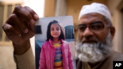 زینب کے والد اپنی مقتول بچی کی تصویر صحافیوں کو دکھا رہے ہیں (فائل فوٹو)