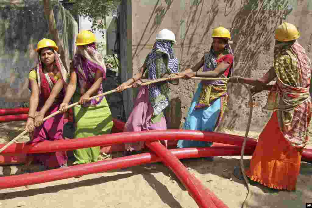 Buruh perempuan tetap bekerja memasang kabel listrik pada Hari Perempuan Internasional (8/3). (AP/Ajit Solanki)