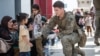 Seorang Marinir AS dengan 24th Marine Expeditionary Unit (MEU) memberikan air kepada seorang anak selama evakuasi di Bandara Internasional Hamid Karzai, Kabul, Afghanistan, 20 Agustus 2021. (Foto: Sersan Samuel Ruiz/Korps Marinir AS via Reuters)