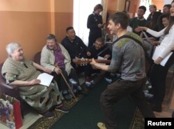 Volunteers entertain women at a nursing home, as part of the "Aging with Joy" charity project, in the settlement of Khatun in Moscow Region, Dec. 13, 2018.