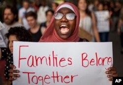 FILE - A woman shouts slogans during a rally against a banning travel from several Muslim-majority nations, in New York, June 26, 2018.
