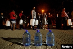 FILE - People queue to collect water from a spring in the Newlands suburb as fears over the city's water crisis grow in Cape Town, South Africa, Jan. 25, 2018.