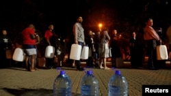 People queue to collect water from a spring in the Newlands suburb as fears over the city's water crisis grow in Cape Town, South Africa, Jan. 25, 2018.