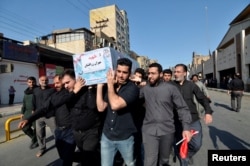 People carry a coffin during a funeral of the victims of assault that killed 25 people, in the streets of the southwestern Iranian city of Ahvaz, Iran Sept. 24, 2018.