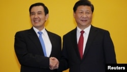 FILE - Chinese President Xi Jinping shakes hands with Taiwan's President Ma Ying-jeou during a summit in Singapore, Nov. 7, 2015. Leaders of political rivals China and Taiwan met on Saturday for the first time in more than 60 years.