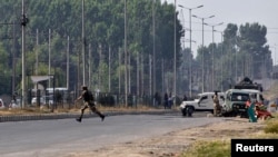 An Indian army soldier runs for cover at the scene of an encounter with separatist militants in Srinagar, June 24, 2013.