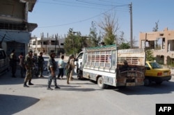 Syrian soldiers and pro-regime militiamen gather in the recently retaken desert town of Al-Qaryatayn on Oct. 22, 2017.