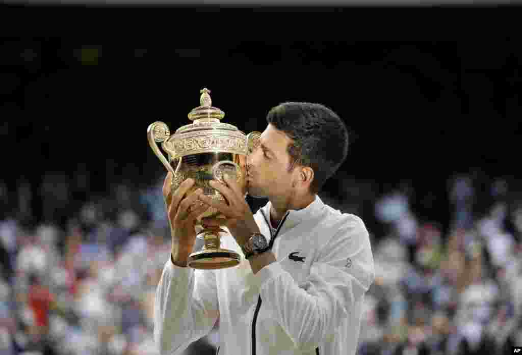 Serbia&#39;s Novak Djokovic kisses the trophy after defeating Switzerland&#39;s Roger Federer in the men&#39;s singles final match of the Wimbledon Tennis Championships in London, July 14, 2019.