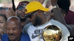 La mégastar de la NBA LeBron Ames tient le trophée du championnat américain du basketball, à Cleveland, 22 juin 2016.