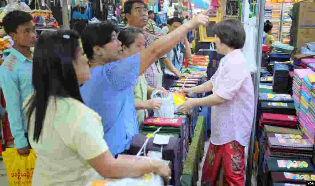 Shoppers in Yangon looking at longyi for sale. (Steve Herman/VOA News)