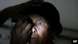 FILE - A patient has an eye exam at a military hospital in Padang Sidempuan, North Sumatra, Indonesia, Nov. 3, 2012. 