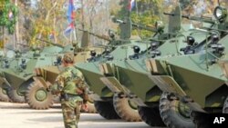 A Cambodian soldier walks past armored vehicles during the National Assembly members' visit to troops in a military base near the Preah Vhear temple in Preah Vihear province, some 500 kilometers northwest of Phnom Penh, February 9, 2011.