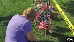 A woman pays her respects at an impromptu memorial near the scene of a shooting for the four U.S. Marines gunned down at an Armed Forces Career Center/National Guard recruitment office in Chattanooga, Tennessee, July 17, 2015. (VOA / S. Behn)