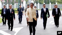 Thai Prime Minister Prayuth Chan-ocha, center, arrives at the government house before a cabinet meeting in Bangkok, Thailand, Tuesday, Sept. 11, 2018. Thailand's military junta announced it will ease some restrictions on political parties to let them conduct basic functions and prepare for elections set for early next year, but campaigning will still be forbidden. 