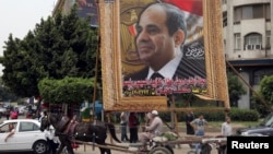  An Egyptian man on horse cart rides past a huge banner for Egypt's former army chief Abdel Fattah al-Sisi in downtown Cairo, May 6, 2014.