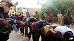FILE - This image appears to show militants from the Islamic State of Iraq and the Levant (ISIL) leading captured Iraqi soldiers after taking over a base near Tikrit, Iraq. The photo was posted on a militant website June 14, 2014. 