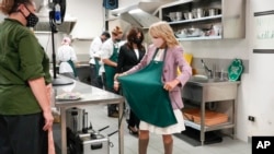 Premye dam Etazuni Jill Biden mete tabliye pou li ka ede elèv lekol kuizin fè ravioli nan vil Naples, ann Itali, 1 Nov. 2021.