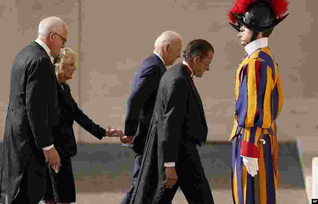 First Lady Jill Biden, second left, reaches out to touch the hand of President Joe Biden as they arrive for a meeting with Pope Francis at the Vatican, Oct. 29, 2021.