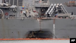 The damaged port aft hull of USS John S. McCain, is seen while docked at Singapore's Changi naval base in Singapore, Aug. 22, 2017. 