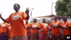 Orange-shirted women promote the health benefits of the orange-fleshed sweet potato during a community theater performance in Uganda.