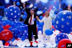Democratic vice presidential nominee Tim Kaine and Democratic presidential nominee Hillary Clinton walk through the falling balloons during the final day of the Democratic National Convention in Philadelphia, July 28, 2016.