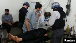 U.N. chemical weapons experts visit people affected by an apparent gas attack, at a hospital in the southwestern Damascus suburb of Mouadamiya, August 26, 2013. 