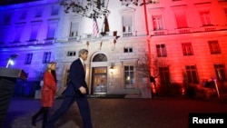 U.S. Secretary of State John Kerry (C), next to U.S. ambassador to France Jane D. Hartley, leaves after delivering a speech at the U.S. embassy in Paris illuminated with the colors of the French national flag, Nov. 16, 2015.