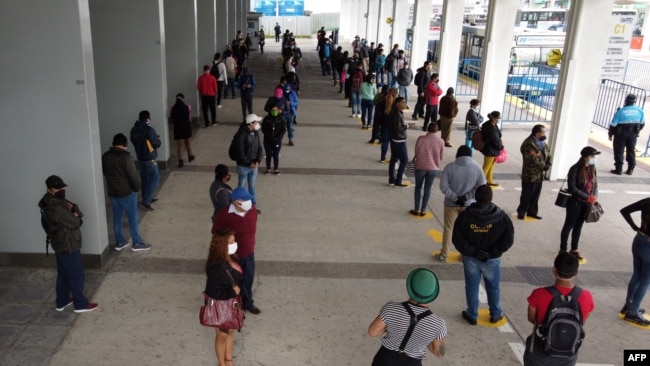 Las personas mantienen su distancia mientras hacen cola en una estación de trolebuses en el norte de Quito, el 3 de junio de 2020, cuando Ecuador comienza a reabrir su economía en medio de la pandemia del nuevo coronavirus COVID-19.