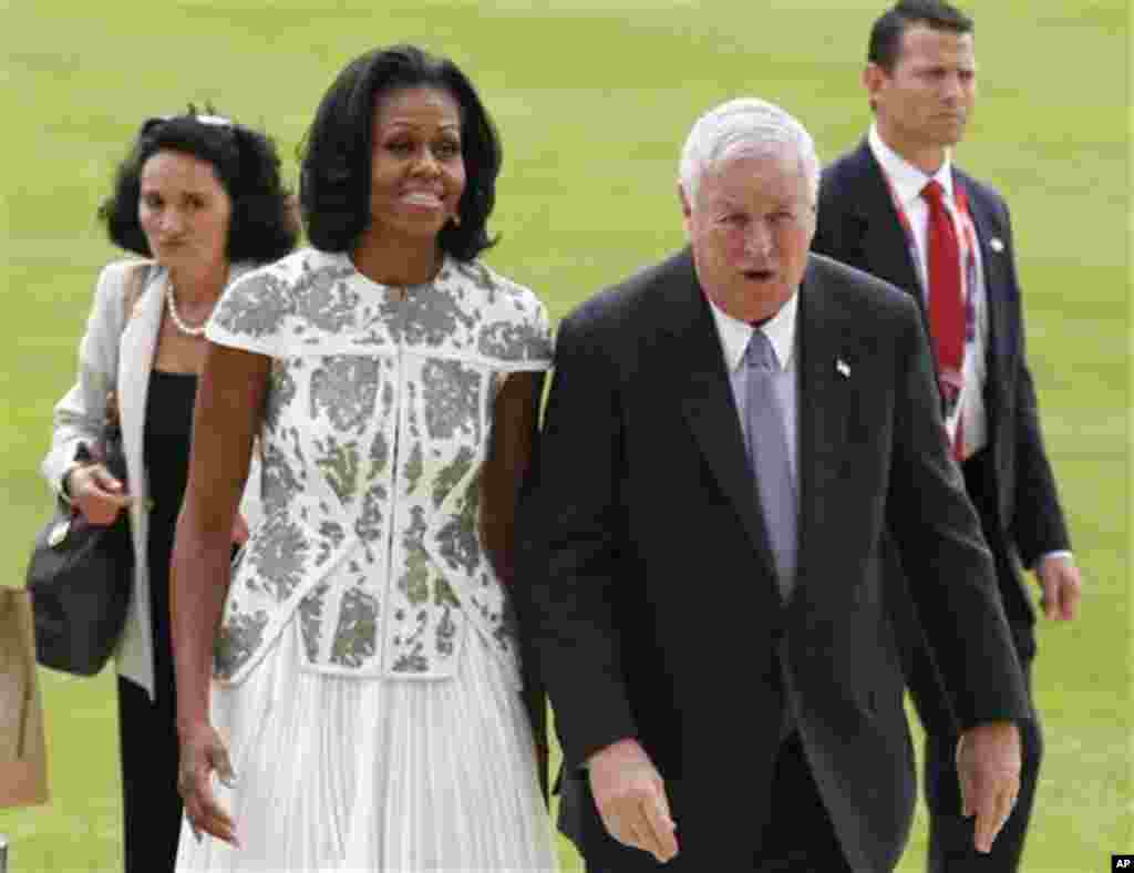 US's first lady Michelle Obama and U.S. Ambassador Louis B. Susman arrive at Buckingham Palace in London for a reception hosted by Queen Elizabeth II for the heads of state and governments prior to them attending the opening ceremony of London 2012 Olympi