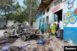 Residents gather at the scene of a suicide car bomb explosion, at the gate of Naso Hablod Two Hotel in Hamarweyne district of Mogadishu, Somalia, Oct. 29, 2017.