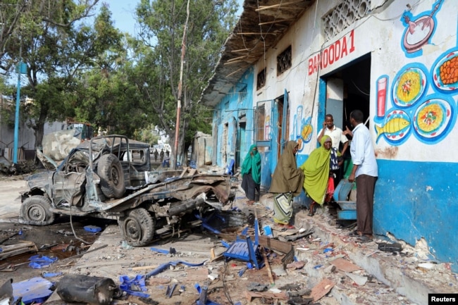 Residents gather at the scene of a suicide car bomb explosion, at the gate of Naso Hablod Two Hotel in Hamarweyne district of Mogadishu, Somalia, Oct. 29, 2017.
