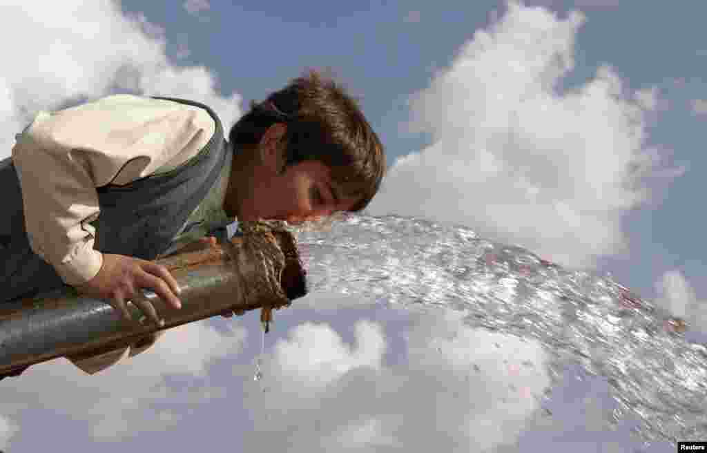 یمن میں ایک بچہ پانی کے پمپ سے پانی پی رہا ہے 