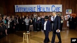 President Barack Obama walks in with volunteer Edna Pemberton before speaking with other volunteers who helped people enroll through the HealthCare.gov site at Temple Emanu-El, Nov. 6, 2013