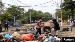 Anti- coup protesters throw garbage on a street after activists launched a "garbage strike"