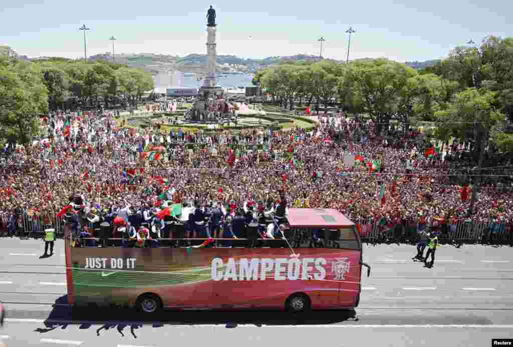 Para pemain timnas Portugal yang baru menjuarai EURO 2016 mengendarai bus terbuka menuju Lisabon.