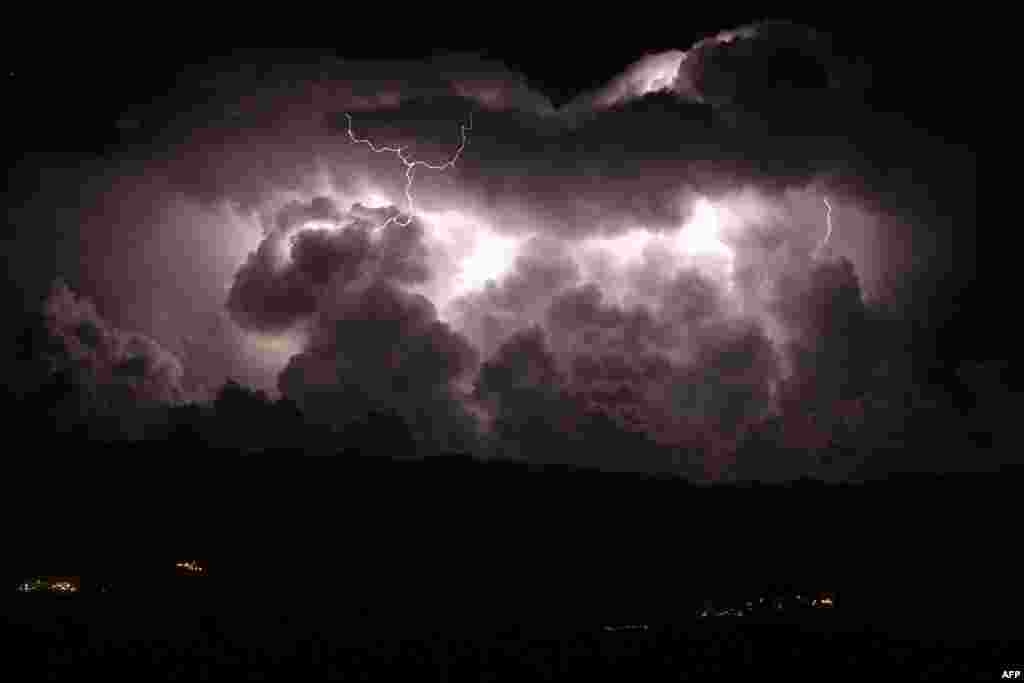A long-exposure photograph shows lightning during a storm over the Taravo Valley and Petreto-Bicchisano village on the French Mediterranean Island of Corsica.