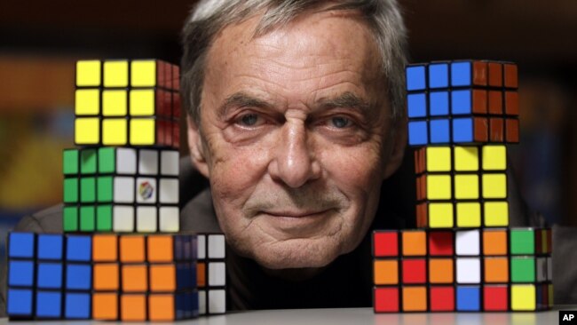 FILE - Erno Rubik, the inventor of the Rubik's Cube, poses with cubes at Liberty Science Center, Wednesday, April 25, 2012, in Jersey City, N.J. An extremely small Rubik’s Cube has gone on sale in Japan for 198,000 yen, or about $1,900. (AP Photo/Julio Cortez)