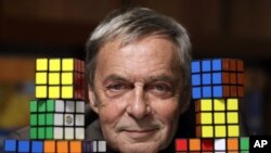 FILE - Erno Rubik, the inventor of the Rubik's Cube, poses with cubes at Liberty Science Center, Wednesday, April 25, 2012, in Jersey City, N.J. (AP Photo/Julio Cortez)