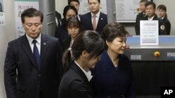 Ousted South Korean President Park Geun-hye, right, leaves after hearing on a prosecutors' request for her arrest for corruption at the Seoul Central District Court, March 30, 2017.