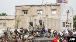 Des éléments des FAMA (Forces armées maliennes) sont célébrés par la population lors de leur passage sur la Place de l'Indépendance à Bamako le 18 août 2020. (Photo AFP)