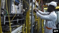Un employé du groupe français de télécommunications Orange mène des travaux de réparation dans un centre technique à Abidjan, le 16 mai 2018.