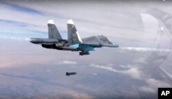 FILE - In this photo made from the footage taken from Russian Defense Ministry official web site on Oct. 9, 2015, a bomb is released from Russian Su-34 strike fighter in Syria.