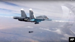 In this photo made from the footage taken from Russian Defense Ministry official web site on Oct. 9, 2015, a bomb is released from Russian Su-34 strike fighter in Syria. 